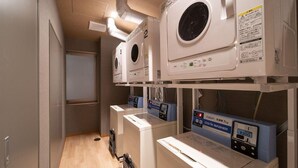 A laundry facility with multiple washing machines and a coin-operated washer. - Super Hotel Premier Saitama Omiyaeki Higashiguchi (Saitama)