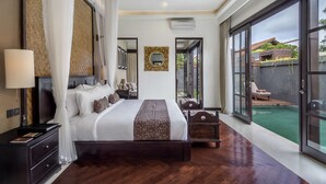 A spacious bedroom with a large bed, a bedside table, a mirror, and a view of a swimming pool. - Luxury Villa for Rent in Bali, Bali Villa 2010 (Bali)