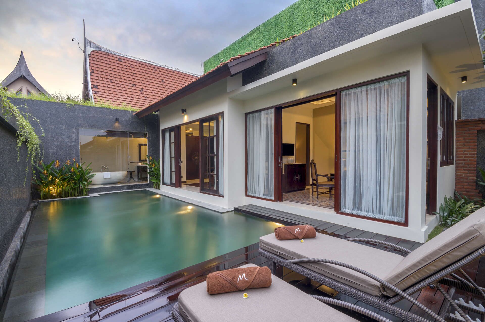 Uma casa moderna com piscina, grandes portas de vidro deslizantes e um jardim bem cuidado.