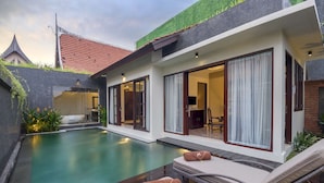 A modern house with a swimming pool, large sliding glass doors, and a well-maintained garden. - Luxury Villa for Rent in Bali, Bali Villa 2010 (Bali)