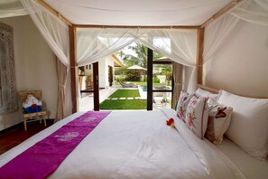 A bedroom with a bed, a purple runner, and a view of an outdoor area with a pool and lounge chairs.