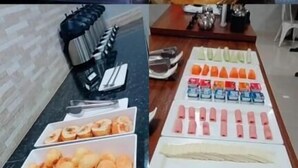 Un buffet proposant une variété de plats, notamment un grand beignet glacé, des pâtisseries assorties et diverses sauces.