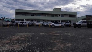 Un immeuble à plusieurs étages avec un parking situé devant.