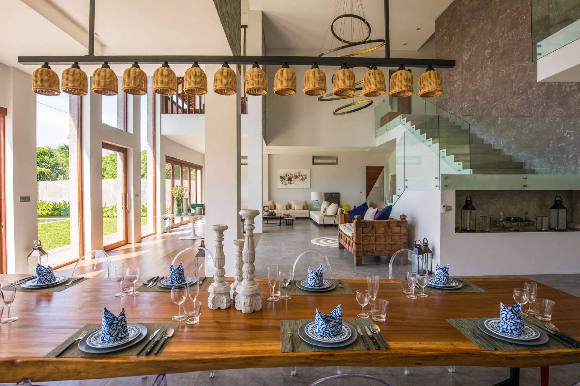 Comedor con mesa de madera dispuesta para seis personas, rodeado de amplios ventanales.