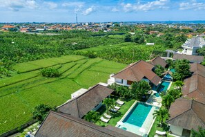 Un quartier résidentiel doté d’une piscine, de champs en terrasses et de maisons aux toits de tuiles.