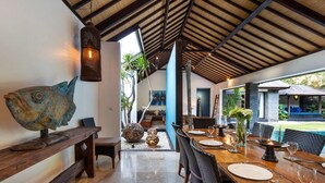 A dining area with a long table, chairs, and a decorative fish sculpture. - 5 Star Villa in Bali, Minutes from the Beach, Bali Villa 2080 (Bali)