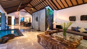 A spacious living area with a pool, a dining area, and a seating area with a sofa and coffee table. - 5 Star Villa in Bali, Minutes from the Beach, Bali Villa 2080 (Bali)