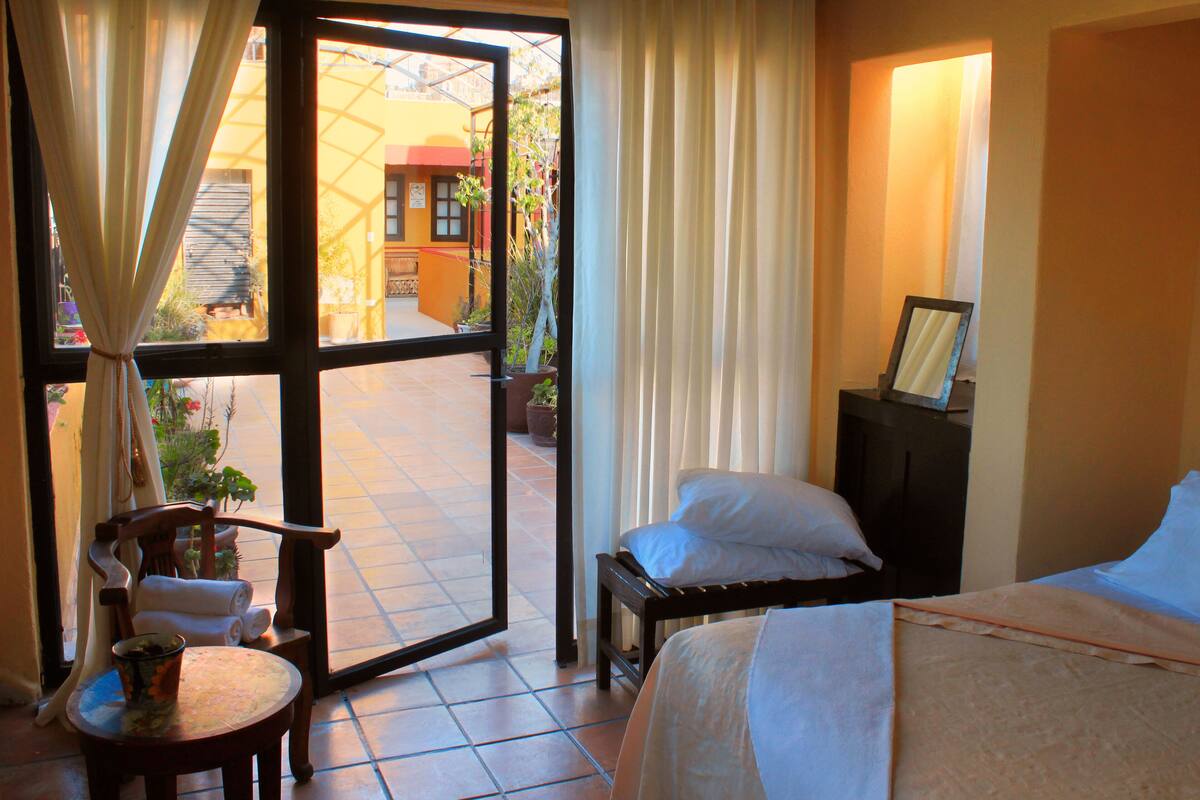 Une chambre d’hôtel avec un lit, une chaise, une petite table et une vue sur l’extérieur.