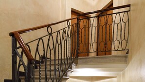 A staircase with ornate black railings and wooden doors at the top. - Comfortable apartment with garden view - Treviso center (Treviso)