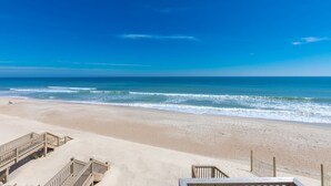 A beach with a wooden boardwalk leading to the shore.