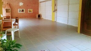 Um quarto amplo com piso de azulejos, parede de tijolos e uma grande porta de garagem.
