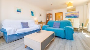 A living room with two sofas, a coffee table, and a dining area with a table and chairs. - PDM CA'N NOFRE - Fantastic cosy house with terrace and with a the beach just 230 metres aw (Muro)