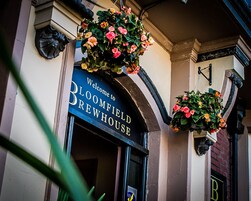 A sign welcoming visitors to the Bloomfield Brewery House.
