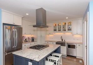 Enjoy cooking in this well-equipped kitchen with a central island, oven, and gas cooktop.