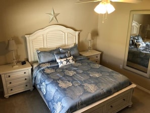 Une chambre à coucher avec un lit, des tables de chevet, une décoration en forme d’étoile et un miroir.