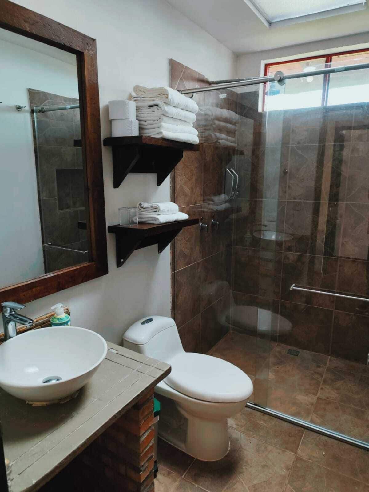 deluxe quadruple room | bathroom | shower, rainfall showerhead, hair dryer, towels