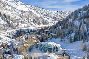 A snow-covered mountain resort with a mix of traditional cabins and modern buildings, a ski lift, and a clear view of the surrounding forest. - Comfort, Convenience, and Modern Amenities at this Ski in/Ski Out Condominium (Alta)