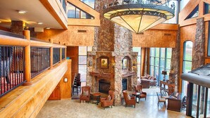 A spacious lobby with a stone fireplace, comfortable seating, and large windows offering views of the outdoors. - Two Bedroom Luxury Villa, Park City, Utah (1920607) (Park City)