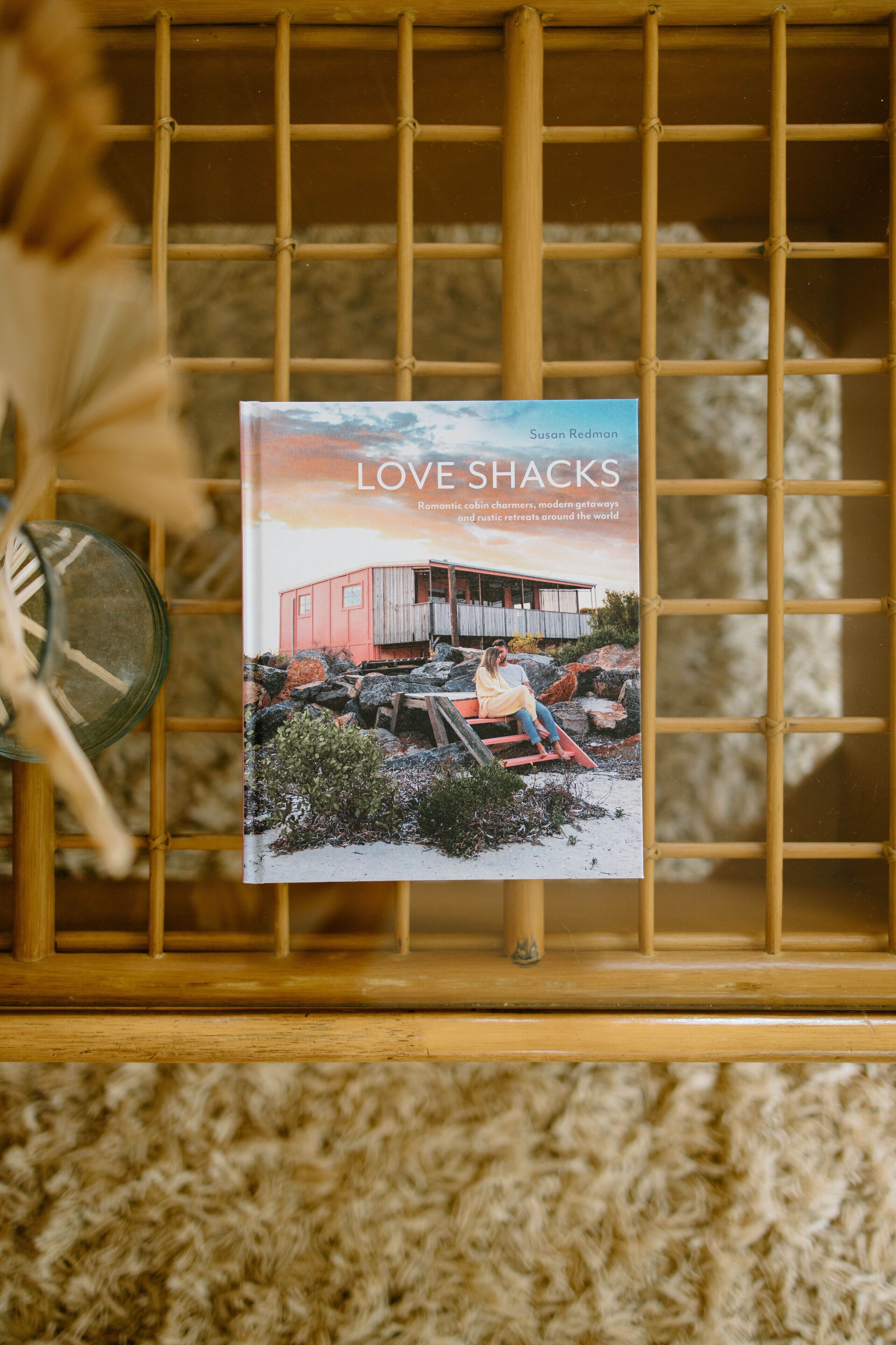A book titled 'LOVE SHACKS' with a cover image of a rustic cabin by a lake.