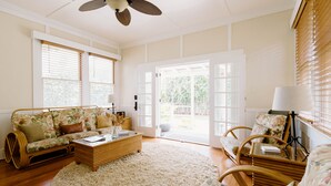 A spacious living room with a large window, a sofa, a coffee table, and a chair. - Hawaiian Charm..Just Steps From The Ocean..On Kauai's Sunny W Side * TVNC4216 (Kekaha)