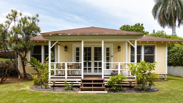 A single-story house with a covered porch, a front yard with a small garden, and a palm tree in the background. - Hawaiian Charm..Just Steps From The Ocean..On Kauai's Sunny W Side * TVNC4216 (Kekaha)