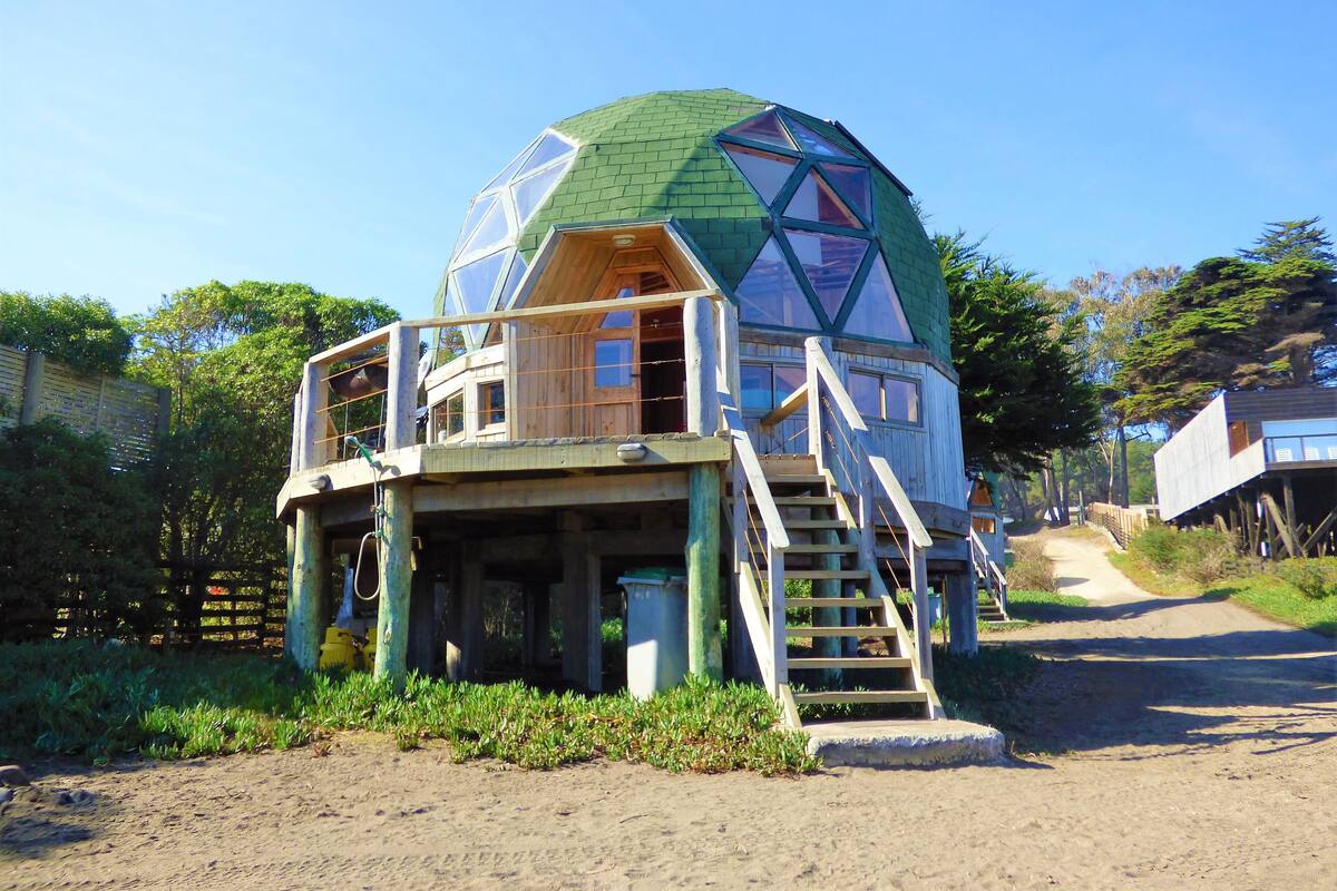 Une structure en forme de dôme géodésique, avec un escalier menant à un niveau supérieur.