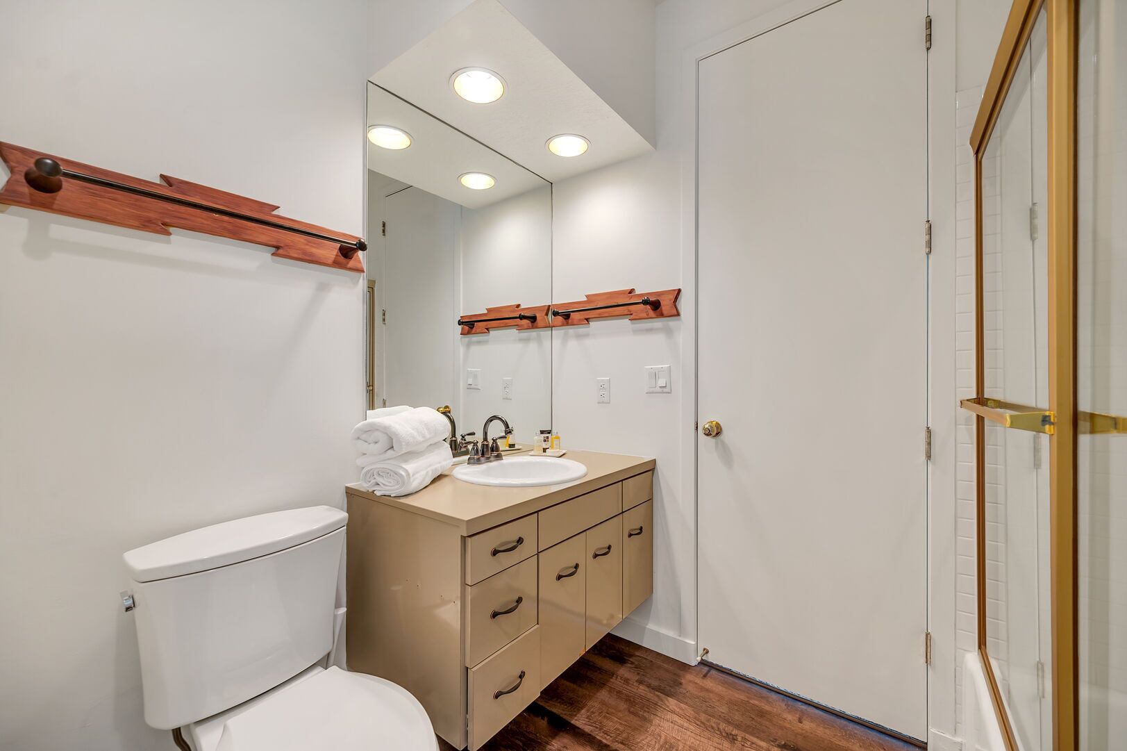 Un baño con inodoro, lavamanos y tocador.