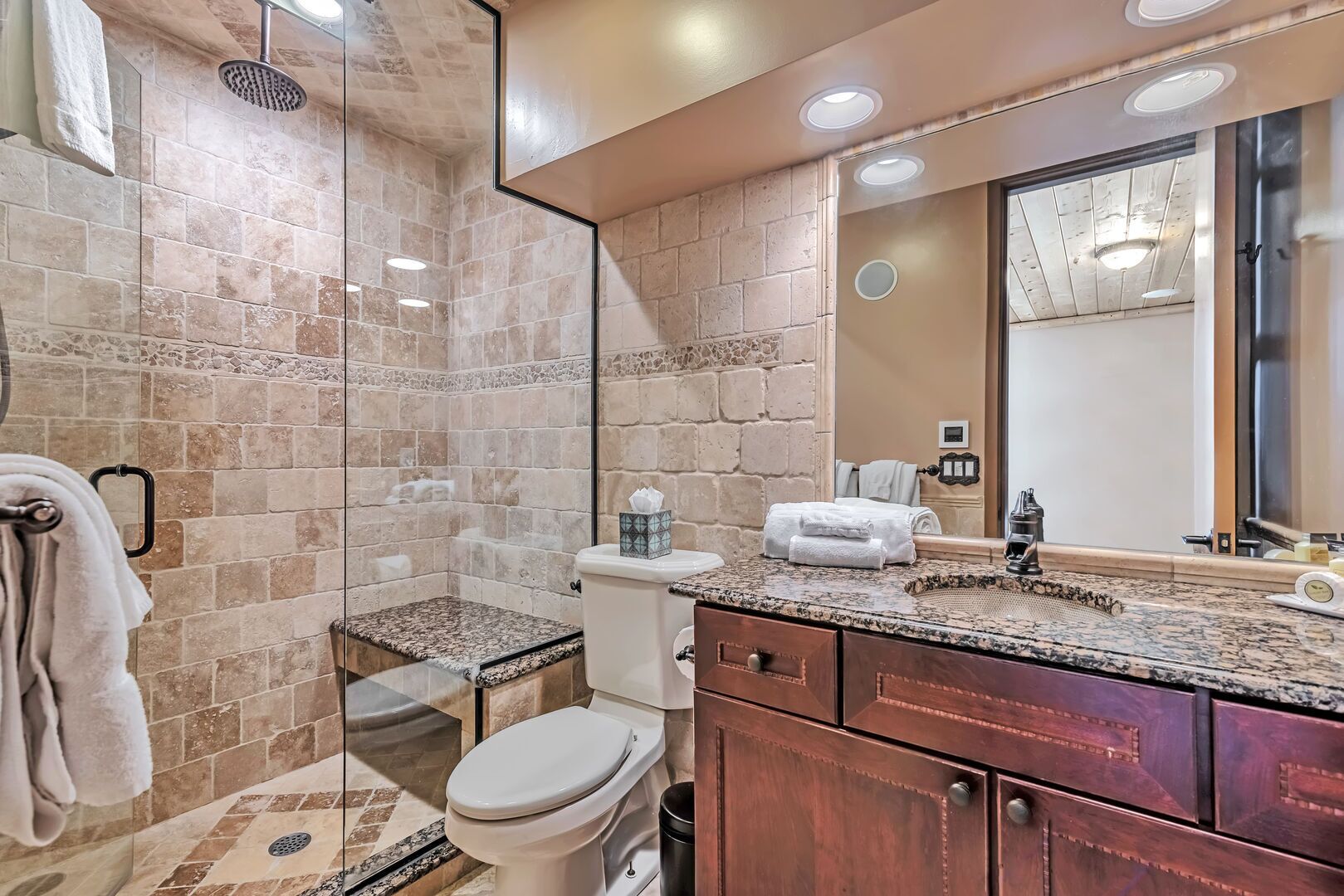 Une salle de bain équipée d’une douche, de toilettes et d’un meuble-lavabo avec un miroir.