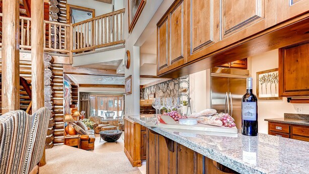 A spacious kitchen with wooden cabinets, a granite countertop, and a wine bottle. - Luxury and Location in this Incredible Home with Brand New Outdoor Hot Tub and 2 Car Garage! (Alta)