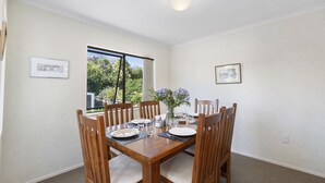 Comedor con una mesa de madera dispuesta para cuatro personas, rodeado de sillas.