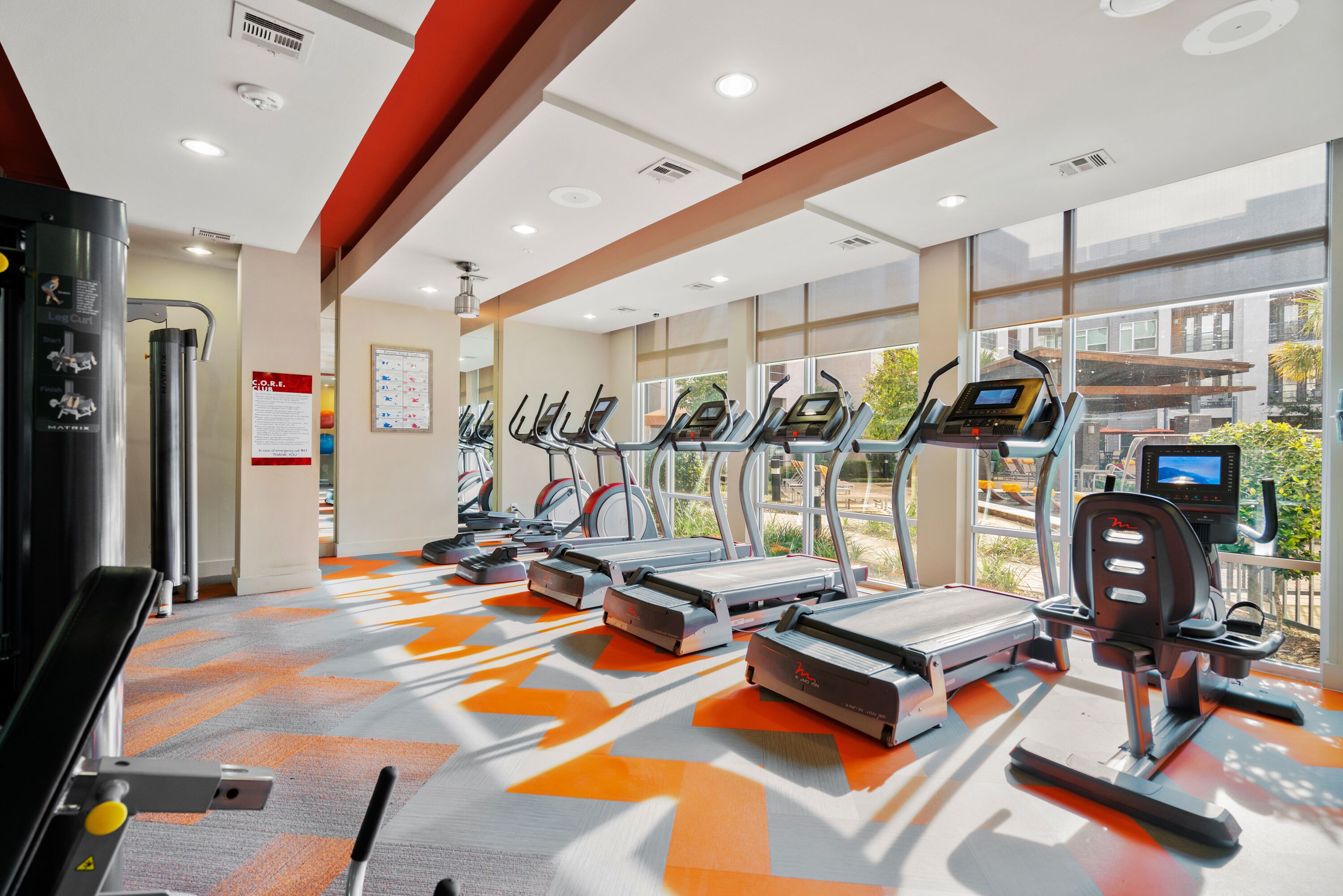 A gym with treadmills, exercise bikes, and a weight machine.