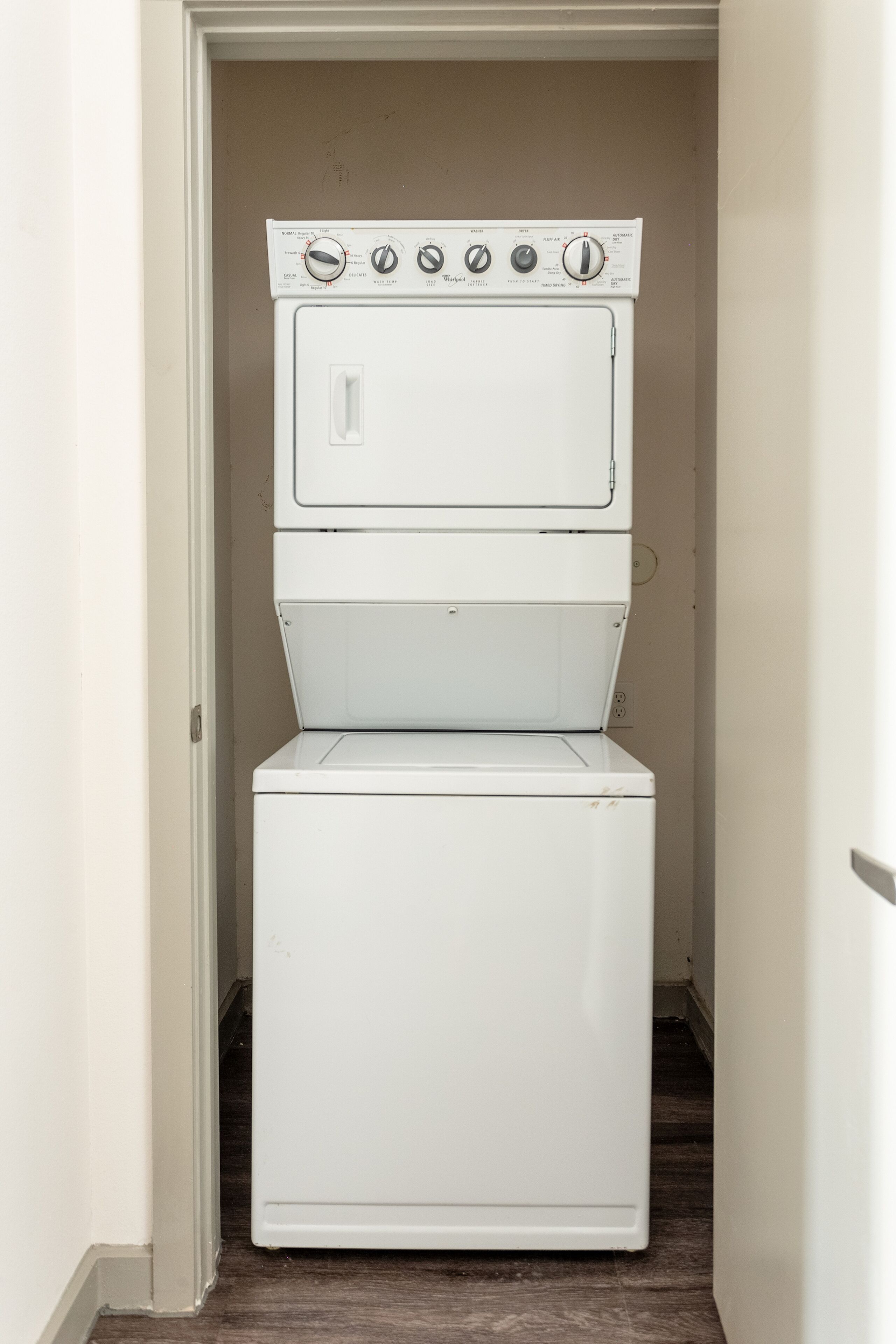 A laundry room with two stacked white washing machines.