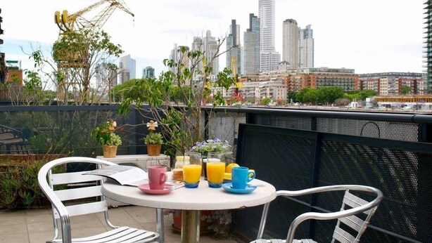 A rooftop terrace with a table set for breakfast, featuring a city skyline view. - Exclusive apartment of 120 m2 overlooking the river and free parking (Puerto Madero)