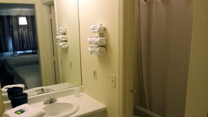 A bathroom with a sink, mirror, towel rack, and toilet. - Walton Inn (Willard)