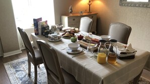 A dining table set with breakfast items, a lamp, and a decorative vase. - La Bicyclette Bleue (Montmorillon)