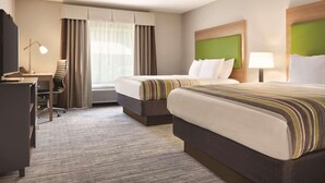A hotel room with two beds, a desk, a chair, a lamp, and a window with curtains. - Country Inn & Suites by Radisson, Greensboro, NC (Greensboro)