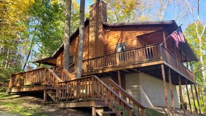A wooden cabin with a balcony, a staircase, and a flag. - Vacation cabin in the beautiful Hocking Hills (Sugar Grove)