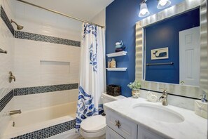 A bathroom with a bathtub, toilet, and sink. - "Always Sunny" Beautifully Remodeled Home, Quick Walk to Beach (Surf City)