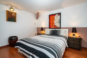 Relax in this serene bedroom with a large bed, two bedside tables, and a beautiful painting above.