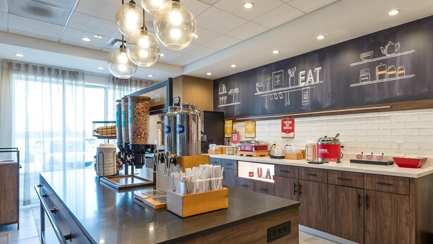 A modern kitchen with a central island, coffee machine, and various kitchen appliances.