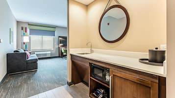 A modern bathroom with a sink, mirror, and built-in microwave.
