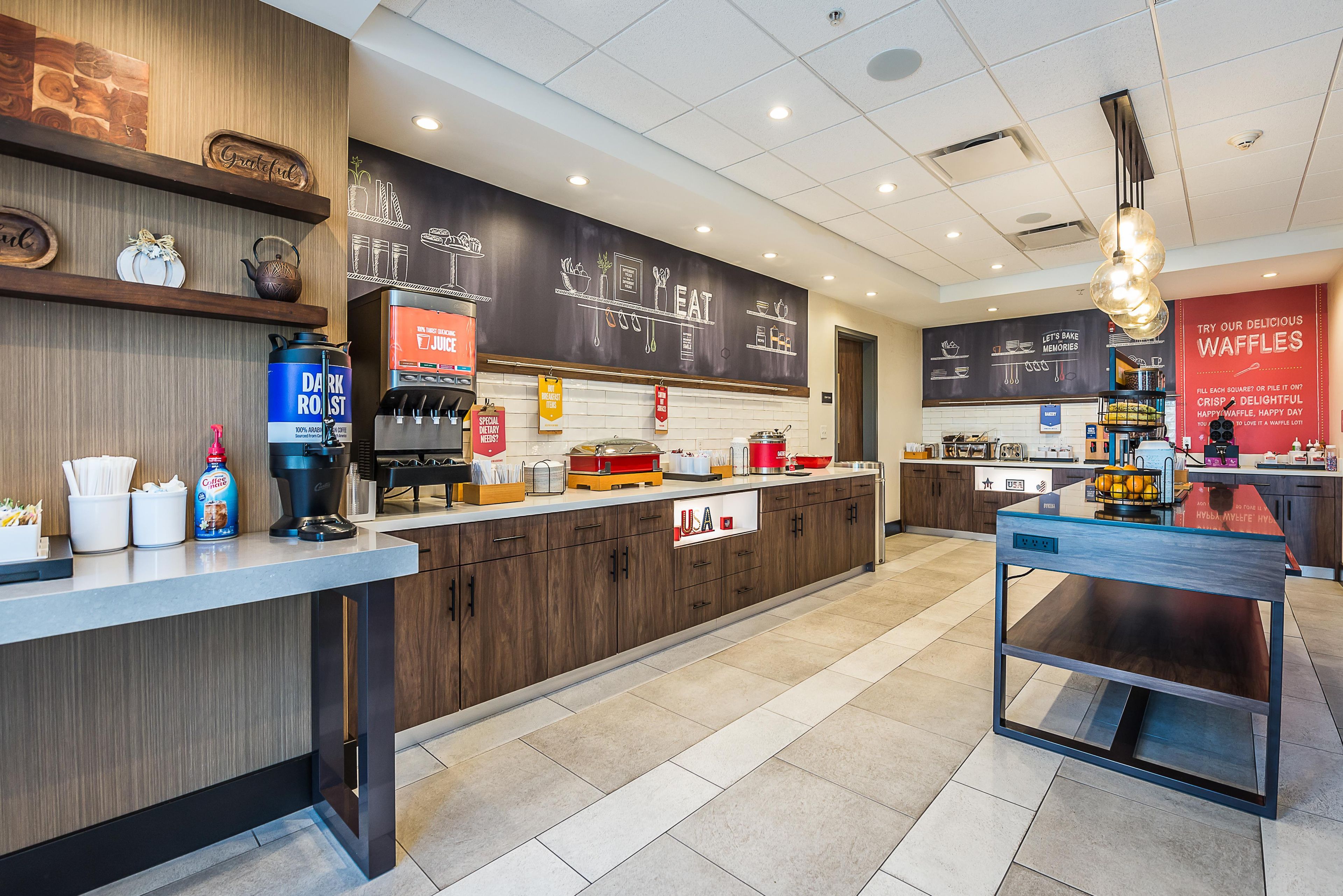 A modern cafe interior with wooden accents, a chalkboard menu, and a counter with various food items.