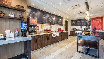 A modern cafe interior with wooden accents, a chalkboard menu, and a counter with various food items.