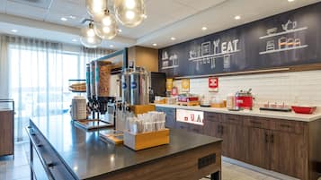 Una cocina moderna con una isla central, cafetera y diversos electrodomésticos.