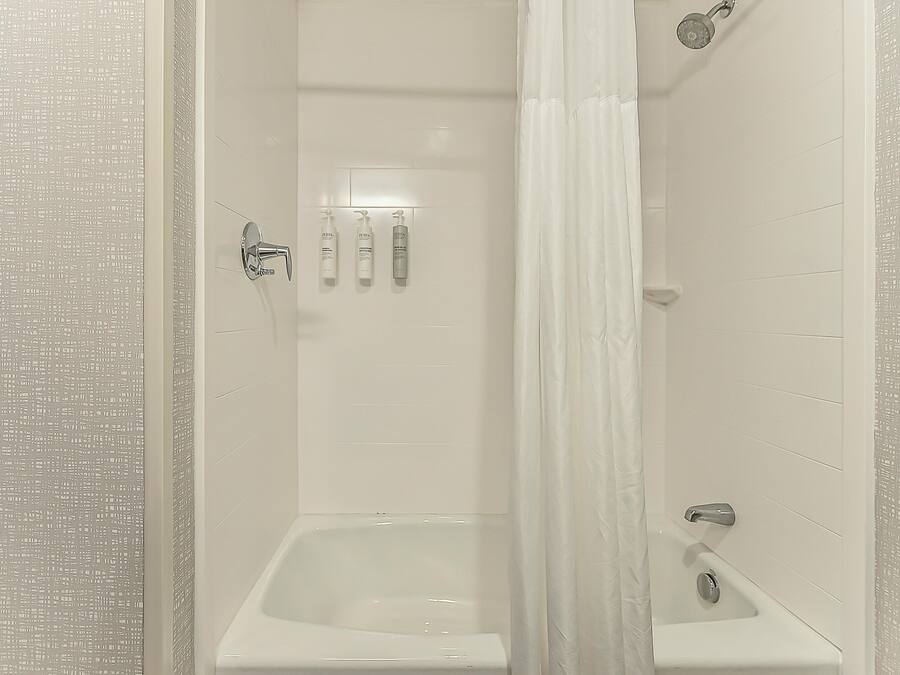 A modern bathroom with a shower, a bathtub, and a toilet.