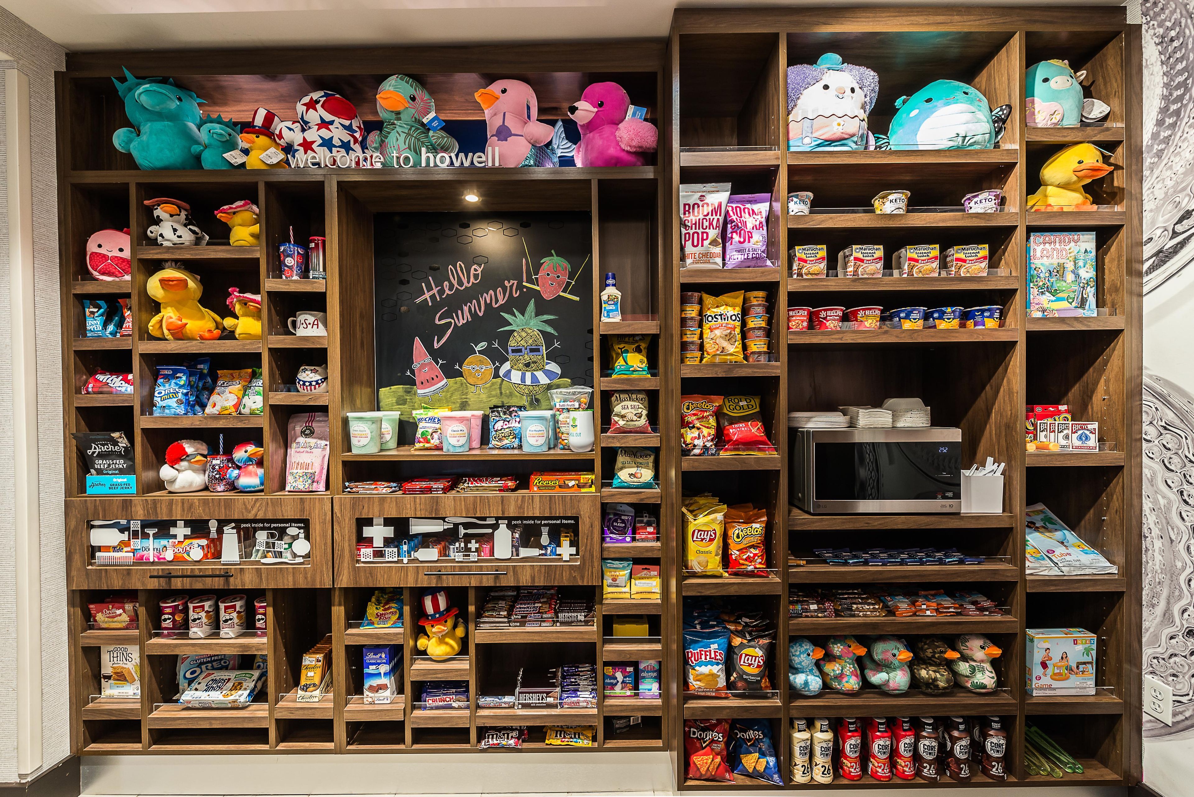Ein übersichtlich bestelltes Regal mit verschiedenen Snacks, Getränken und Spielzeug.