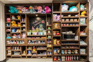 A well-organized shelf with various snacks, drinks, and toys.