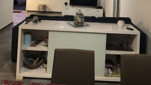 Ein modernes Wohnzimmer mit Fernseher, Esstisch und Sofa.