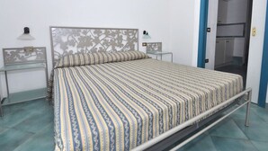 A bedroom with a bed, two bedside tables, a wall-mounted lamp, and a wardrobe. - Residence a Palinuro ID 558 (Palinuro)