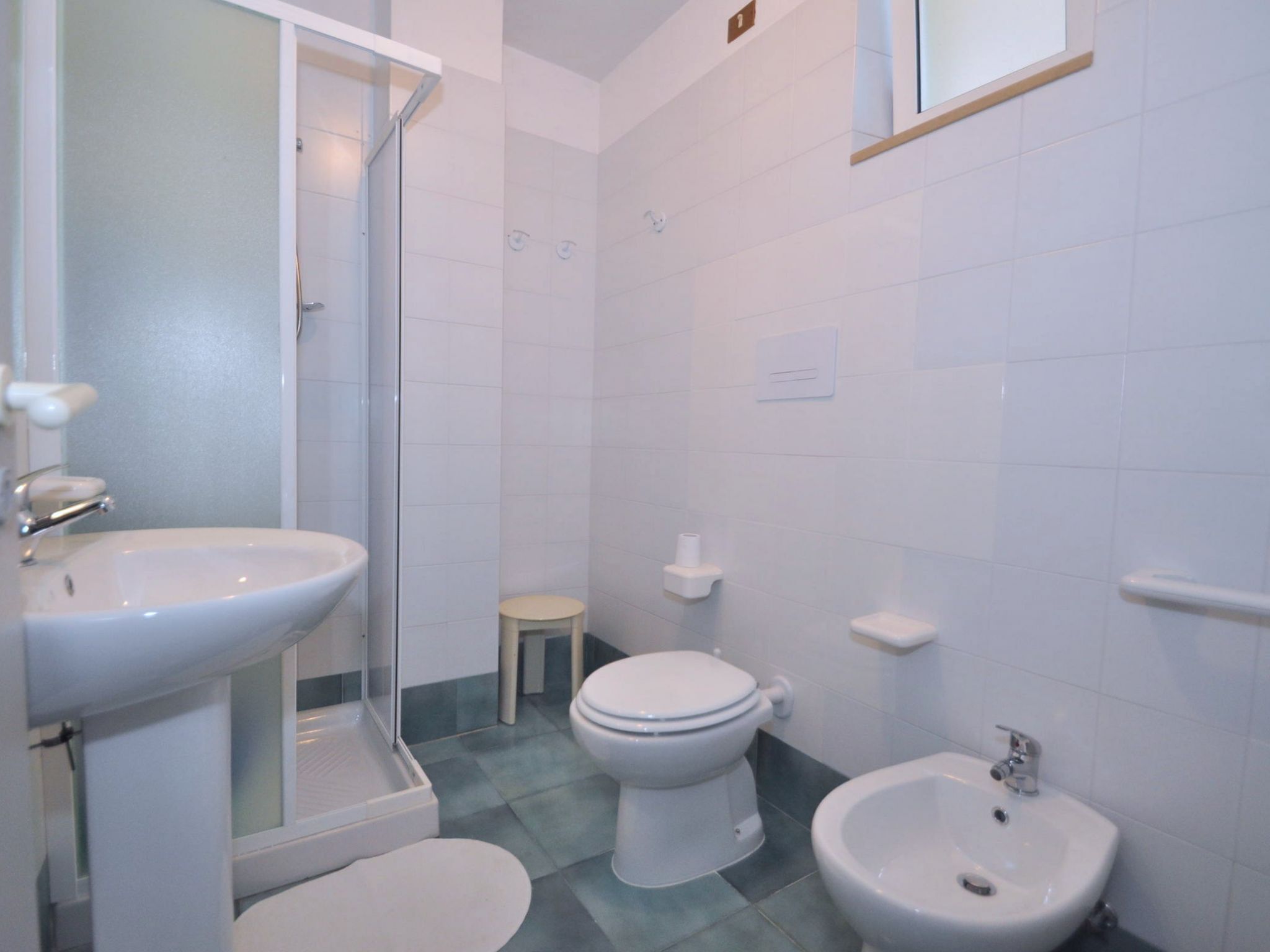 Ein Badezimmer mit Waschbecken, Toilette, Bidet und Duschkabine.
